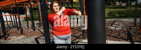 A confident woman exercises energetically in an outdoor fitness area. Stock Photo