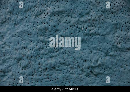 A textured wall with rough plaster creating an uneven, porous surface. Stock Photo