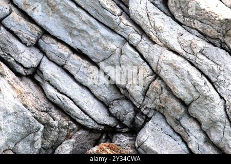 Rock stone wall close up with layers of rock formation texture. Natural wallpaper. Cliff. Pattern. Horizontal photo. No people, nobody. Stock Photo