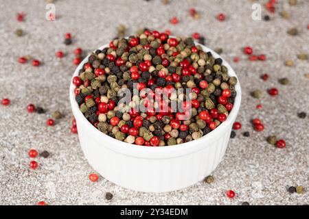 Multicolored peppercorns on a stone gray background. Stock Photo
