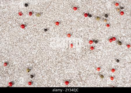 Multicolored peppercorns on a stone gray background. Stock Photo
