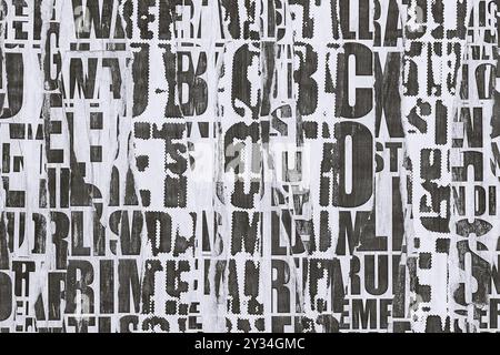 Collage of torn street posters. Abstract black and white lettering background. Stock Photo