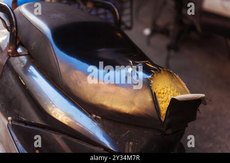 Torn and ruined hole leather motorcycle seat Stock Photo