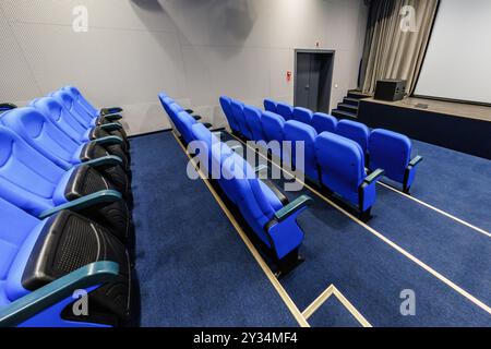 interior of dark conference concert hall or cinema theatre with blue seats Stock Photo