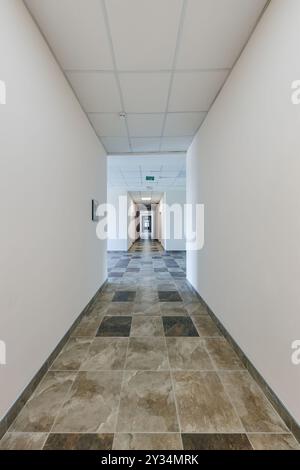empty long corridor with red brick walls and doors in interior of modern apartments or office Stock Photo