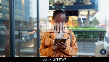 Phone, night and research with black woman in city for communication, connection or technology. Chief automation office, ai engineer and rpa software Stock Photo