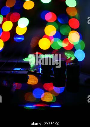 Blurred bokeh Christmas lights reflected on the surface of the guitar. Christmas and New Year celebration concept. Background wallpaper, banner. Stock Photo