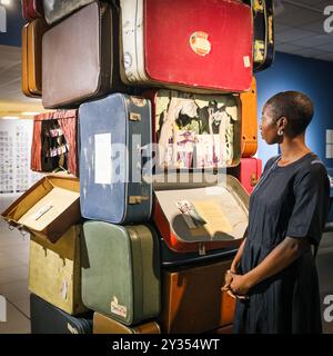 London, UK. 12th Sep, 2024. Museum staffer Kimberley with 'Worlds Apart', by Becky-Dee Trevenen, 2020, an installation highlighting the experiences encountered by those who emigrate. The new exhibition 'All Our Stories: Migration and the Making of Britain' opens with a press preview at the Migration Museum in Lewisham today. The new exhibition highlights how migration has shaped who we are in Britain - as individuals, as communities and as a nation. Credit: Imageplotter/Alamy Live News Stock Photo