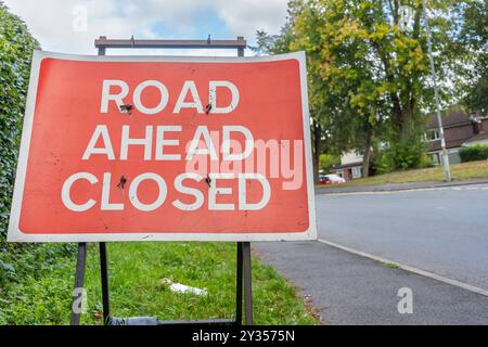 Close view of a road ahead closed sign on the side of a highway. Stock Photo