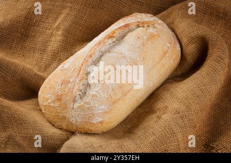 Studio shot of a sourdough loaf on a hessian background - John Gollop Stock Photo