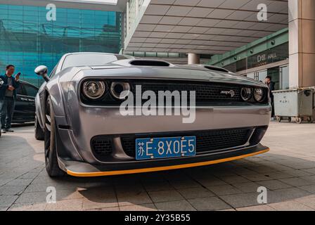 A close-up shot of a custom-tuned Dodge Challenger at a car show Stock Photo