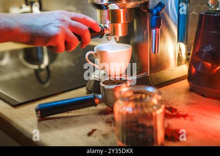 Barista operating an espresso machine. Home kitchen interior. Colorful lights. Stock Photo