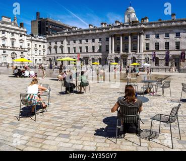 Cafe tables in the central courtyard of Somerset House home of the Courtauld Art Gallery on a sunny summer day with people enjoying the fountains Stock Photo