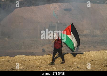 Gaza, Palestine, 19th March 2019. A number of Palestinians are injured by Israeli live fire and tear gas during clashes north of Beit Lahia in the northern Gaza Strip, near the Gaza-Israel maritime fence. Hundreds of Palestinians were holding the 25th protest against the Israeli naval blockade and siege on Gaza, with some demonstrators throwing stones towards the fence, and according to Gaza's Health Ministry at least 20 protesters were injured by live ammunition fired by Israeli soldiers located on the other side of the fence. During the protest, which has been organised by Gaza's National Au Stock Photo