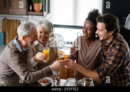 Multi generation multiethnic family having fun, talking around a festive kitchen table. Stock Photo
