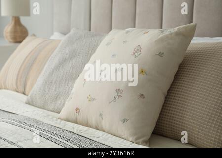 Different color pillows on bed in bedroom, closeup Stock Photo