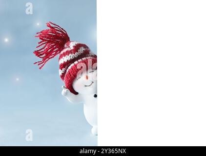 One little snowmen in caps on blue and white background in the winter. Festive background with a funny snowman. Christmas card, copy space. Stock Photo