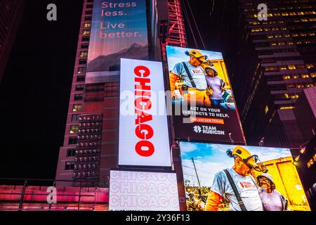 Close-up view of Manhattan skyscrapers at night on Times Square with illuminated billboards featuring Chicago musical. New York. USA. Stock Photo