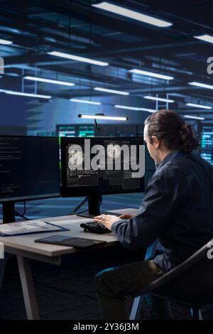 Technician working in data center overseeing international user traffic on computer. IT worker in server room facility hosting websites and delivering web content to online customers Stock Photo