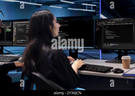 Programmer in data center using PC to check for server performance issues caused by low disk space. IT professional in server hub establishment fixing errors slowing down hardware Stock Photo