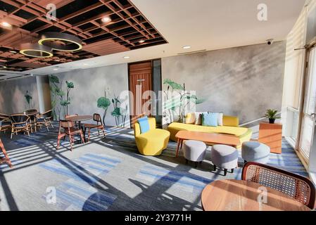 Modern office cafetaria with decorative plant on the wall, warm light with empty chair and table. Office Pantry. Stock Photo