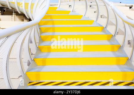 White staircase with a yellow stripes. Bright yellow and white stairway leading upwards, showcasing a clean and inviting design Stock Photo