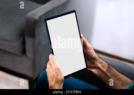 Man holding a tablet computer with blank screen for mockup. White screen for place your design. Stock Photo