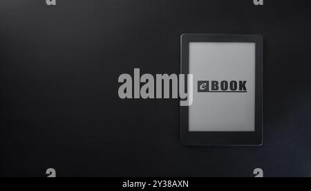 Digital reading concept with ebook with text on screen isolated on black table. top view. Stock Photo