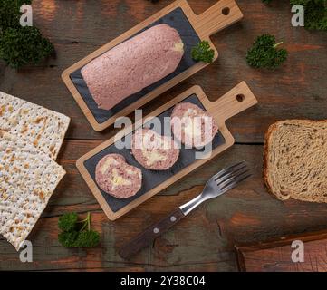 Sliced chopped ham terrine with eggs serving on wooden table with bread Stock Photo