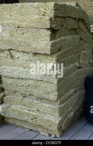 Bales of insulation material stored in a wooden barn during daylight hours Stock Photo