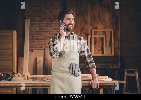 Photo of happy guy using cell smart phone call in garage workshop Stock Photo