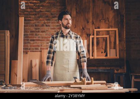Photo of professional thoughtful master dressed uniform apron indoors house diy studio room Stock Photo