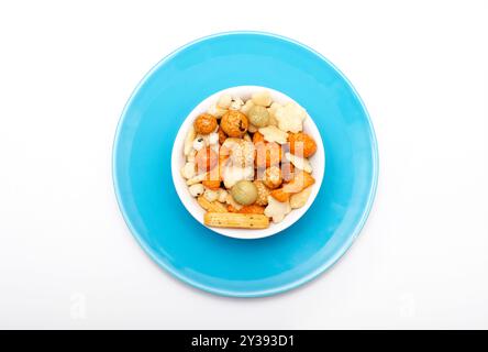 japanese style rice crackers in white bowl on blue plate, on white background Stock Photo