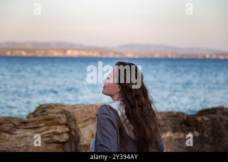 profile of beautiful woman with long hair on the beach at sunset Stock Photo