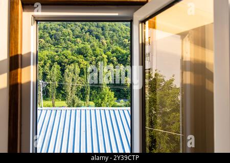 view of roof and forest through open window on sunny summer day in Dilijan city, Armenia Stock Photo