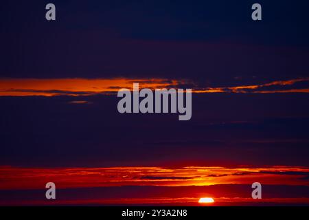 Radiant sunbeams streaming through soft clouds. Fantastic red clouds with twilight Stock Photo