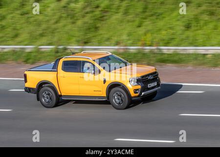 2023 Yellow Ford Ranger Wildtrak Ecoblue 4,  turbocharged EcoBlue 2.0-litre Diesel engine; motoring on the M6 motorway, Manchester, UK Stock Photo