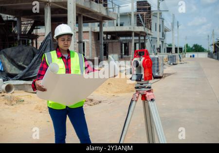 Engineers holding blueprint project working outdoors building side with blueprints on a worksite, Engineering and architecture concept, Engineer worki Stock Photo