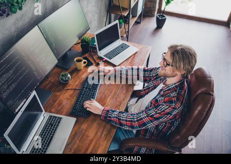 Top view photo of blond hair geek software developer sitting leather boss armchair doing his daily meetings indoors office room Stock Photo
