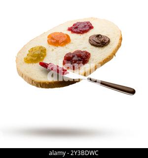 Slice of white bread with variety of jam spread and knife flying on white background. Stock Photo