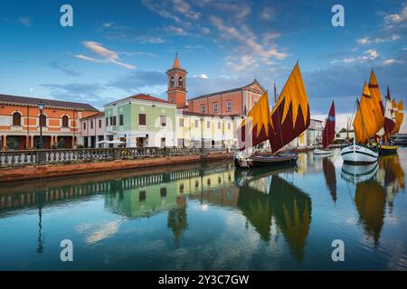 Cesenatico canal, historic wooden sailboats and church at sunset. Emilia Romagna region, Forlì Cesena province, Italy Stock Photo