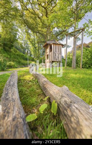 Wooden hut in the background, tree trunks for balancing on a playground, Nagold, Black Forest, Germany, Europe Stock Photo