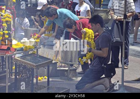 Worshippers with incense sticks at prayer, Erawan Shrine, Bangkok, Thailand, Asia Stock Photo