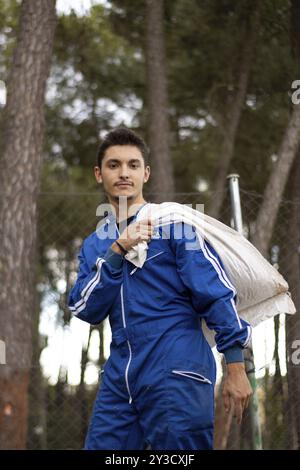 Portrait of a young male veterinarian in blue uniform carrying a textile bag on his shoulder Stock Photo