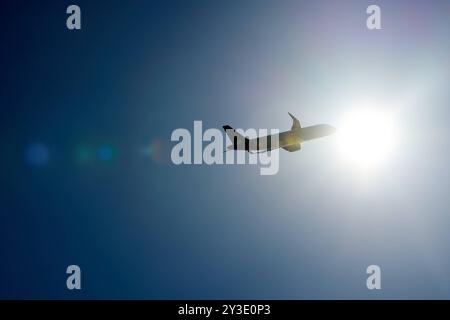 August 31, 2024: An airplane in the sky flies into the bright light of the sun *** Ein Flugzeug am Himmel fliegt in das helle Licht der Sonne Stock Photo