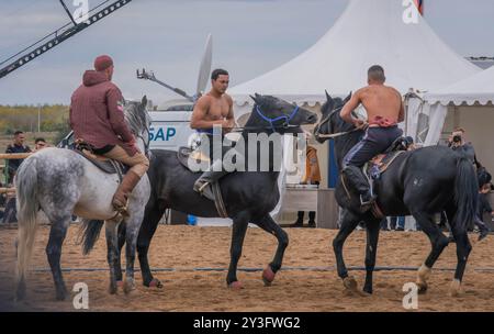 The mounted athletes are wrestling in Audaryspak competition, a traditional horse rider fight, during the World Nomad Games in Astana, Kazakhstan. Stock Photo