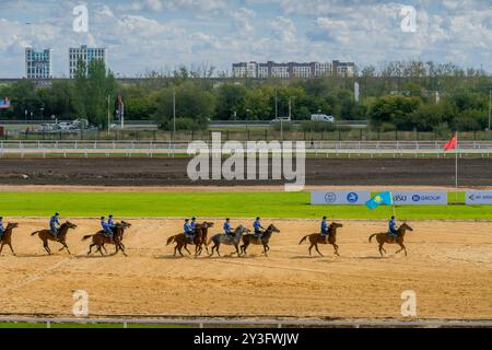 The Kazakh and Uzbek horse riders at kokpar (kok boru) game,  a traditional Asian sport competition, during World Nomad Games, Astana, Kazakhstan. Stock Photo