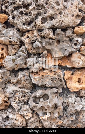 Beautiful textured stone wall. Stone wall texture for wall and wallpaper. Old limestone wall irregular bricks stones textured background. Stock Photo