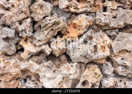 Beautiful textured stone wall. Stone wall texture for wall and wallpaper. Old limestone wall irregular bricks stones textured background. Stock Photo