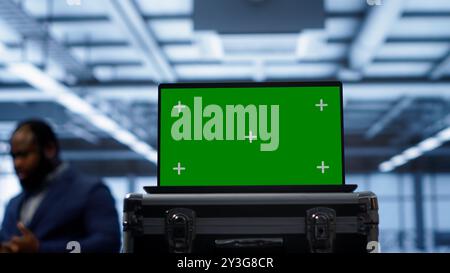Green screen laptop used by engineers monitoring server room, doing checkup. Focus on chroma key notebook used by IT support employee working in data center facility, camera A close up Stock Photo